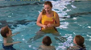 swim instructor teaching kids to swim