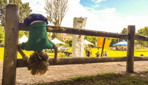 Kid hanging from fence in summer camps