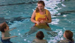 Swim instructor in the pool teaching children to swim
