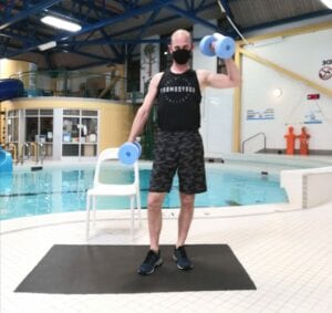 instructor stands on the pool deck for aquafit